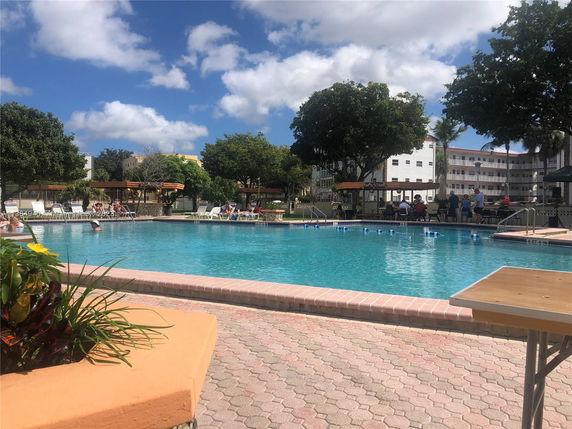 Outdoor swimming pool area with surrounding buildings.