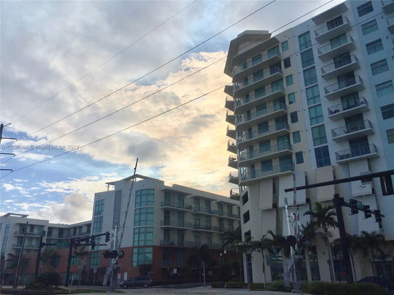 Front view of a modern multi-story residential building with balconies.