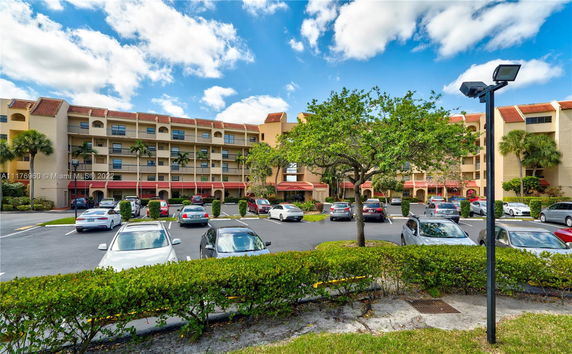 Front view of a multi-story residential building with an open parking area.
