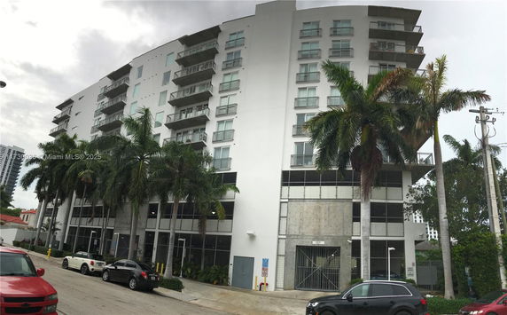 Front view of a multi-story apartment building with balconies.