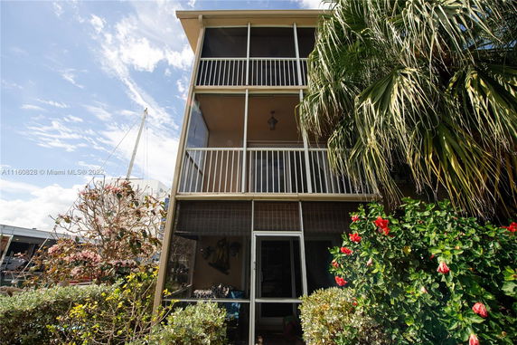 Front view of a multi-story building with screened balconies.