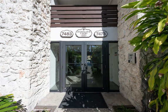 Entrance of a building with stone walls and glass doors.