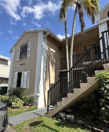 Front view of a two-story building with external staircase.