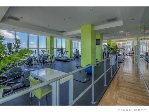 Indoor gym area with exercise equipment and large windows.