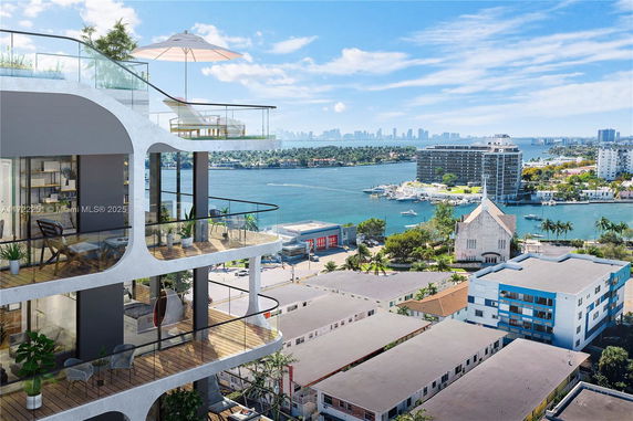 View of a building with balconies overlooking water and surrounding cityscape.