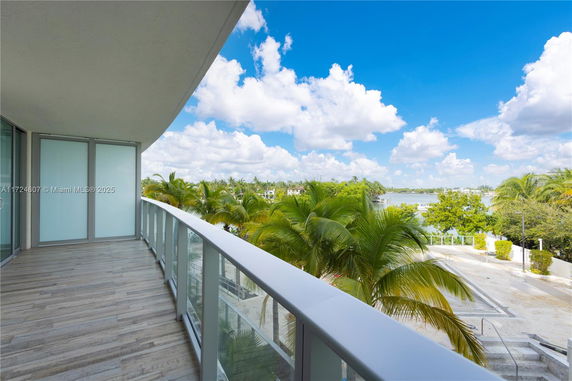 Balcony view overlooking tropical vegetation and a body of water.
