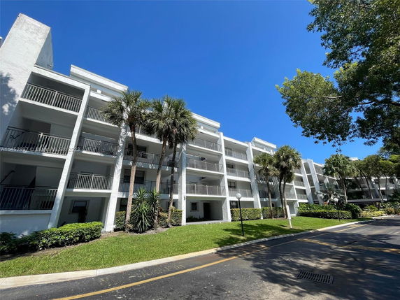 Front view of a multi-story apartment building with balconies.