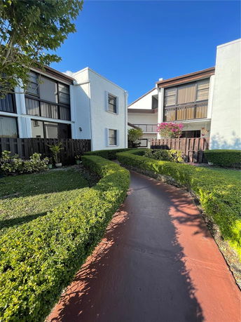 Front view of a two-story building with windows and a garden path.
