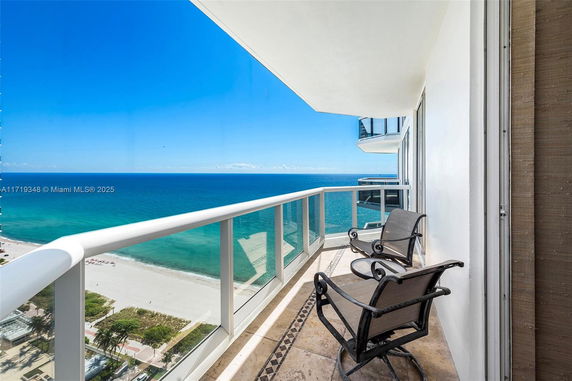 Balcony view overlooking a beach and ocean.