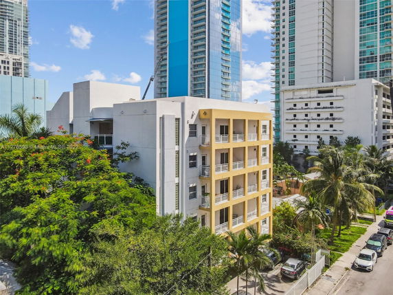 Front view of a multi-story residential building with balconies in an urban area.