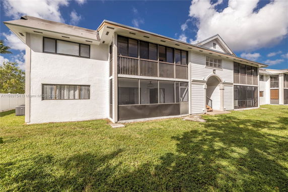 Front view of a two-story house with a screened balcony.