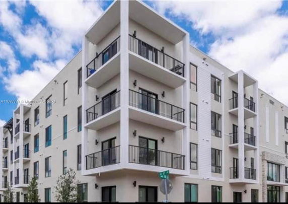 Front view of a multi-story apartment building with balconies.