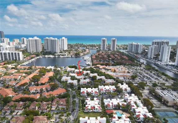 Aerial panoramic view of a coastal city with residential areas and high-rise buildings near the ocean.