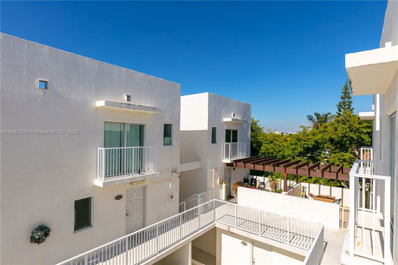 View of modern apartment complex with white exterior walls and small balconies.