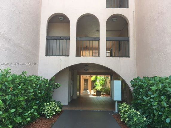 Front view of a building with arched openings and a walkway entrance.