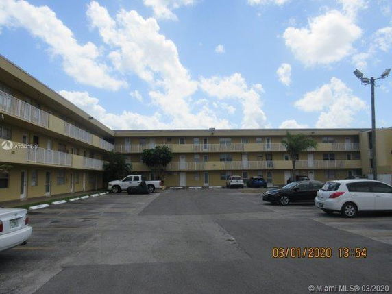 Parking area in front of a multi-story residential building.