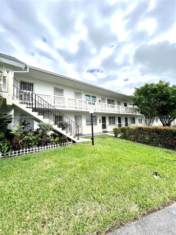 Front view of a two-story residential building with exterior stairs.