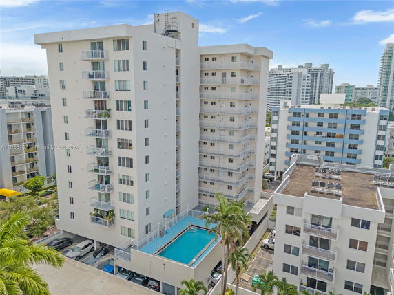 Front view of a multi-story apartment building with balconies.
