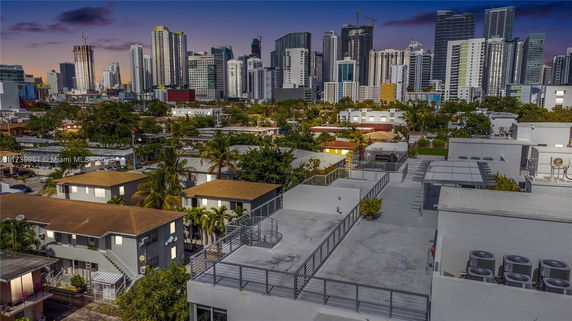 View of cityscape with multiple buildings and rooftops in the foreground.
