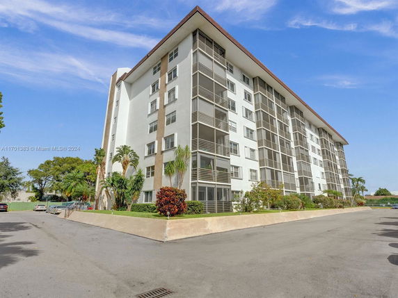 Front view of a multi-story apartment building with balconies.
