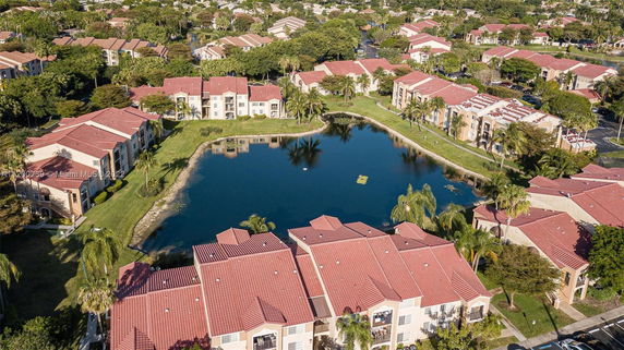 Aerial view of a residential area with multiple buildings and a central pond.