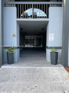 Entrance of a building with two potted plants and an arched opening.