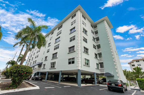 Front view of a multi-story building with parking underneath.