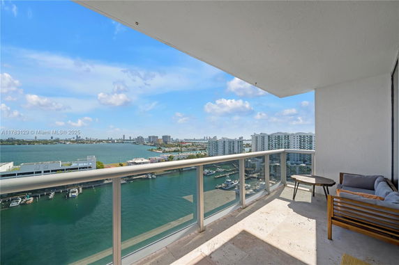 View from a high-rise building balcony overlooking the water and distant cityscape.
