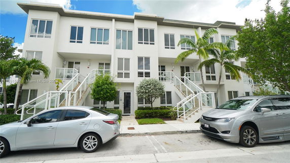 Front view of a three-story residential building with multiple staircases.