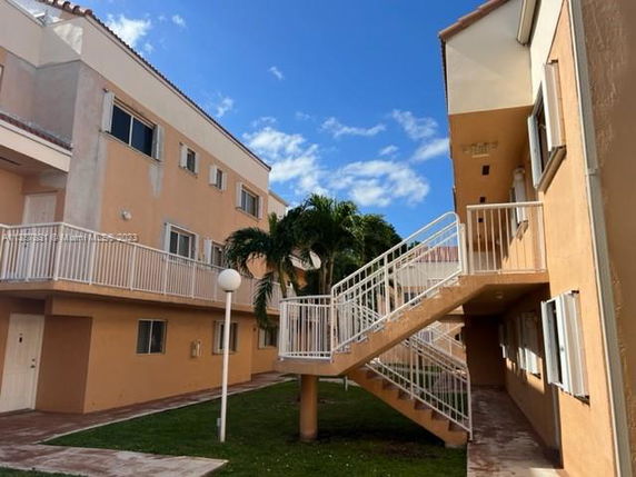 Front view of a multi-story apartment building with exterior staircases.