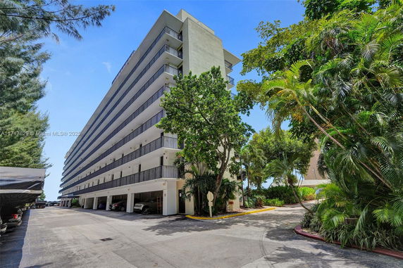 Front view of a multi-story residential building with parking area.