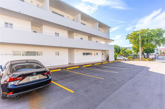 Outdoor parking area in front of a multi-story building.