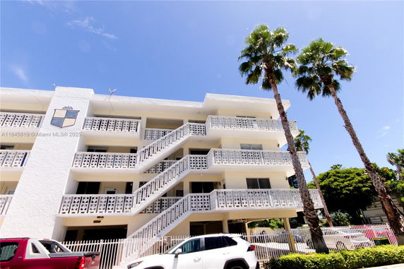 Front view of a multi-story building with decorative railings and exterior staircases.