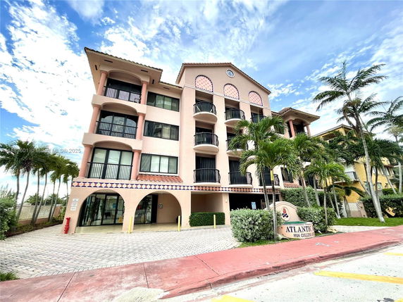 Front view of a multi-story building with balconies and an arched entrance.