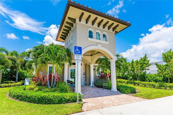 Front view of a house with arched entrance and columns.