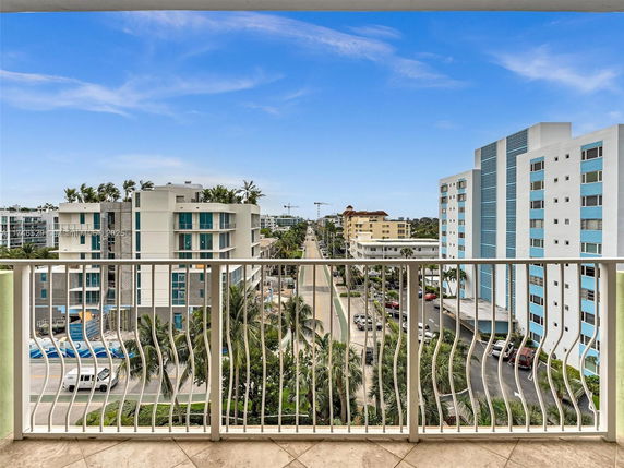 Panoramic view of a street lined with modern apartment buildings as seen from a balcony.