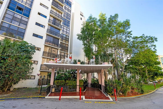 Front view of a multi-story residential building with a decorated entrance canopy.