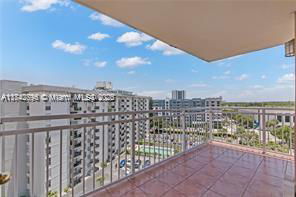 View from a balcony showing surrounding buildings and a clear sky.