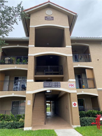 Front view of a multi-story apartment building with balconies.