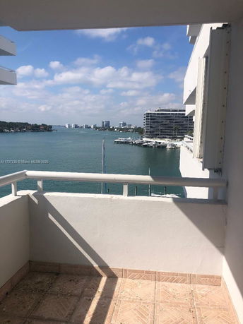 View from a balcony overlooking a body of water and distant buildings.