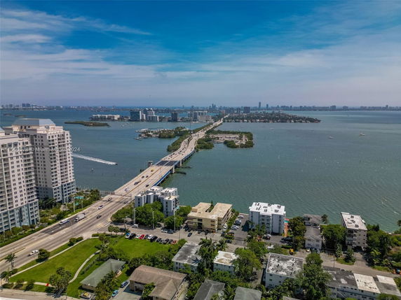 Panoramic view of a cityscape with buildings, roads, and a body of water.