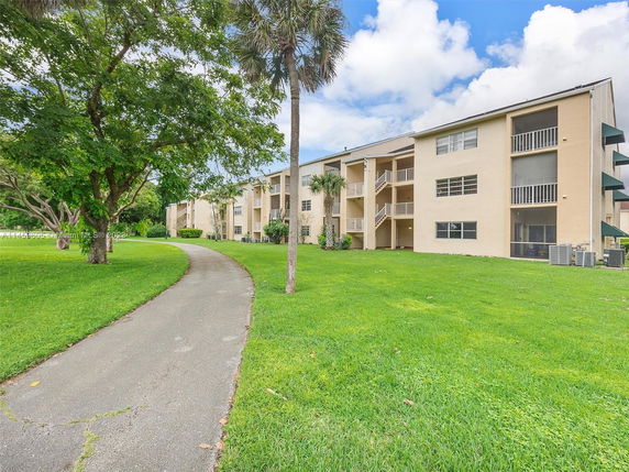 Front view of a three-story apartment building with balconies.