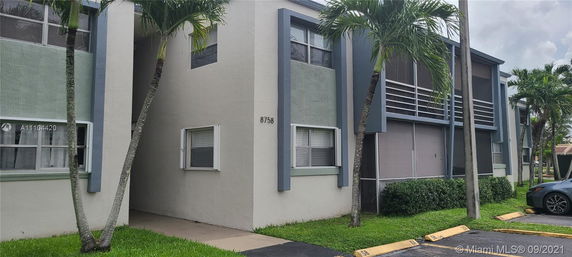 Front view of a multi-story building with a modern design and numbered 8758.