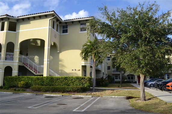 Front view of a two-story building with arched entrances and an external staircase.