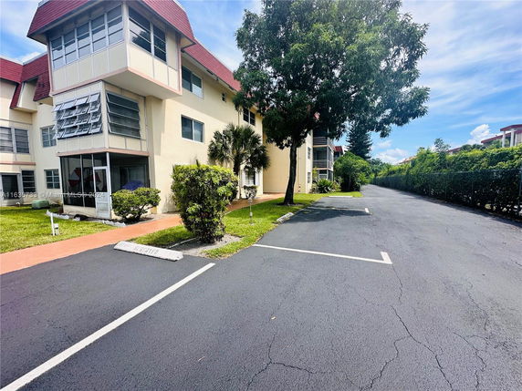 Parking area outside a multi-story residential building.