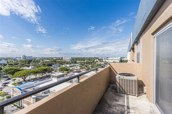 View of surrounding areas seen from a building with a visible air conditioning unit on the balcony.