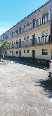 Front view of a three-story apartment building with balconies.