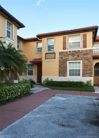 Front view of a two-story house with decorative stone facade and attached garage.