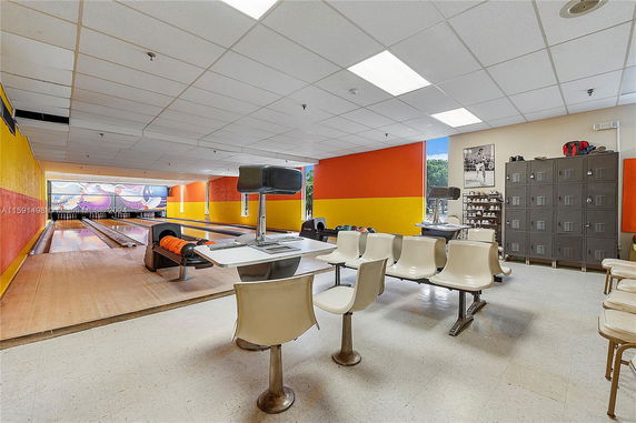 Indoor bowling alley with seating area, lockers, and colorful walls.
