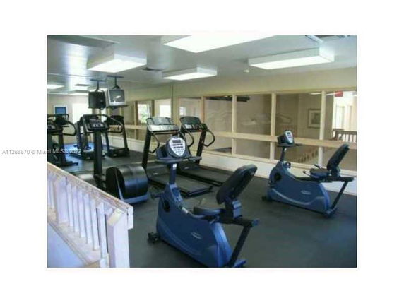 Indoor gym area with exercise equipment, including treadmills and stationary bikes.